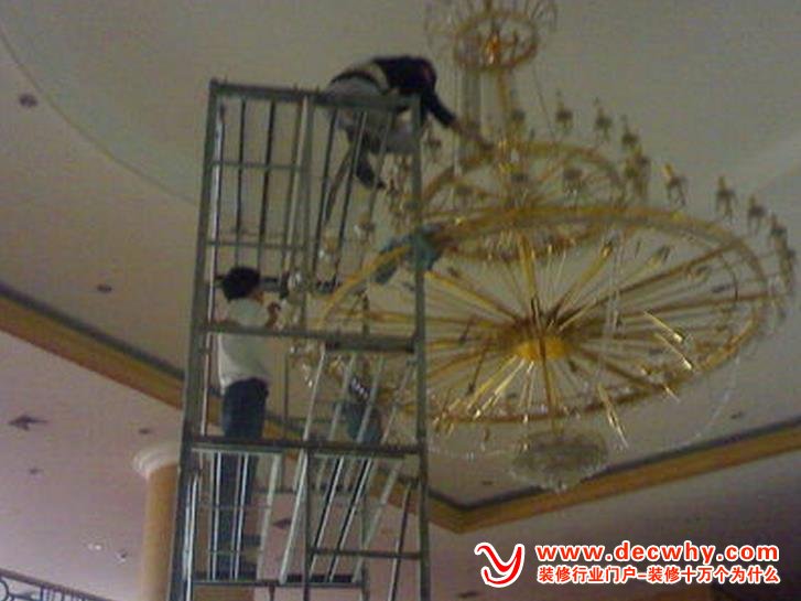 工人正在安装大型水晶吊灯
