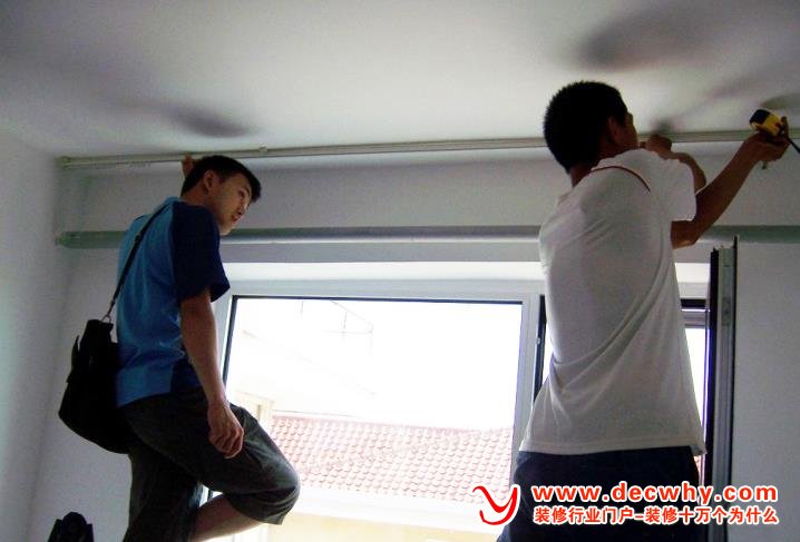工人师傅正在安装窗帘杆